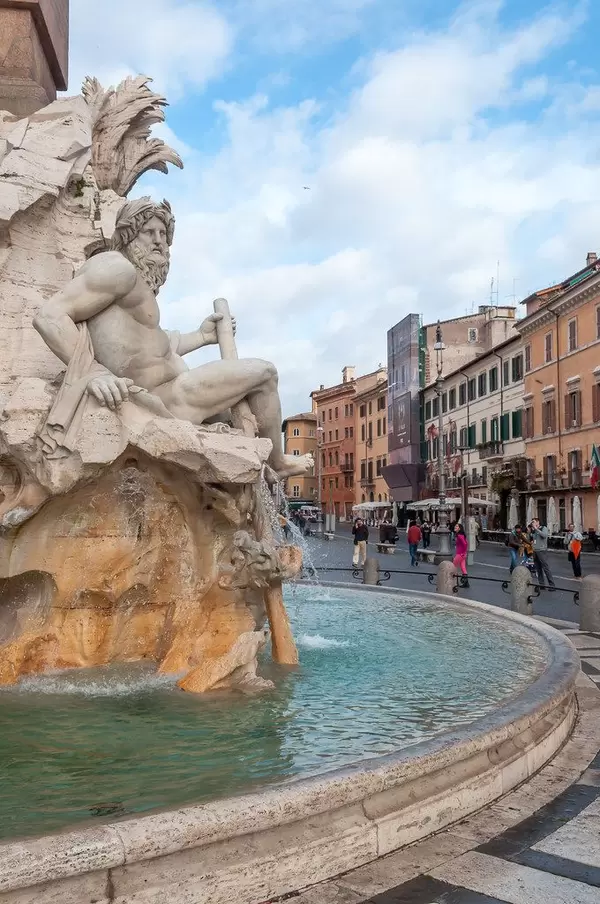 Zeus statue sits on a fountain with a round water basin