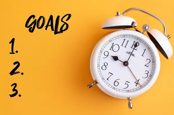 Zielsetzung 2020: Weißer Wecker mit dem Text ‘Goals’ vor gelbem Hintergrund