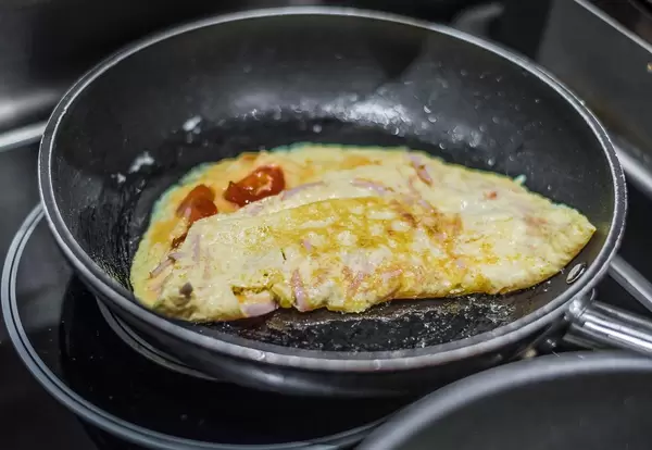 Zubereitung eines Omelettes mit Schinken und Tomate