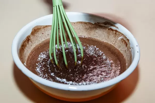 Zubereitung von Fondantkuchen mit grünem Schneebesen