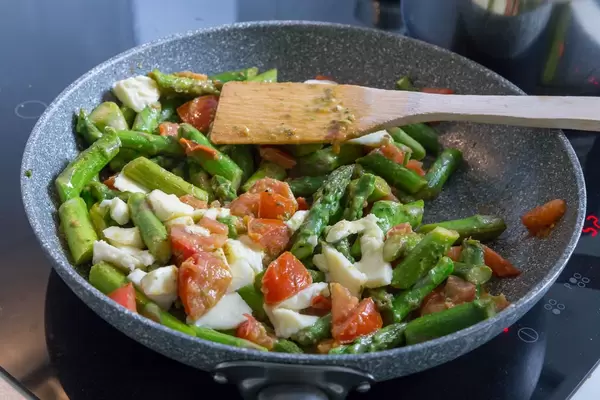 Zubereitung von grünem Spargel mit Penne, Tomate und Mozzarella