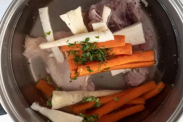 Zubereitung von Hühnerfleischsuppe mit Pastinaken, Möhren und Kräutern