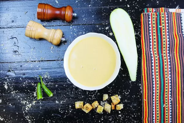 Zucchinicremesuppe mit Croutons: veganes Rezept aus der Balkanküche, Aufnahme von oben mit schwarzem Hintergrund