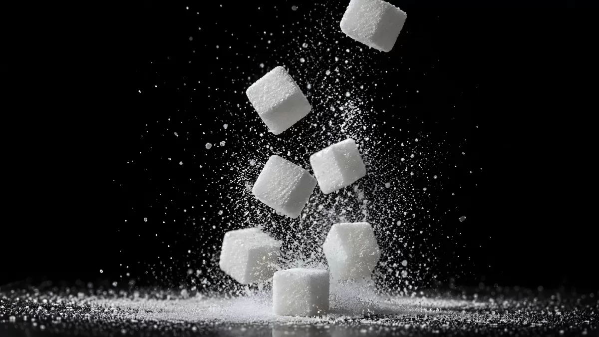 Zuckerwürfel fallen auf schwarzem Hintergrund
