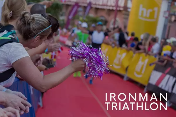 Zuschauer und Sportenthusiasten feuern die Ironman Triathlon Teilnehmer auf der Marathonstrecke an