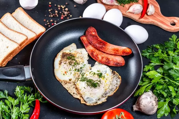 Zutaten für Frühstück und Spiegeleier in einer Pfanne