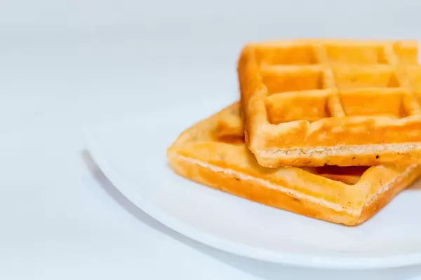 Zwei aufeinander gestapelte belgische Waffeln vor weißem Hintergrund