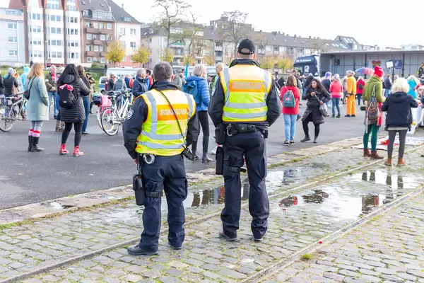 Zwei Beamte vom Ordnungsamt überwachen die Demo gegen die Corona-Maßnahmen in Köln