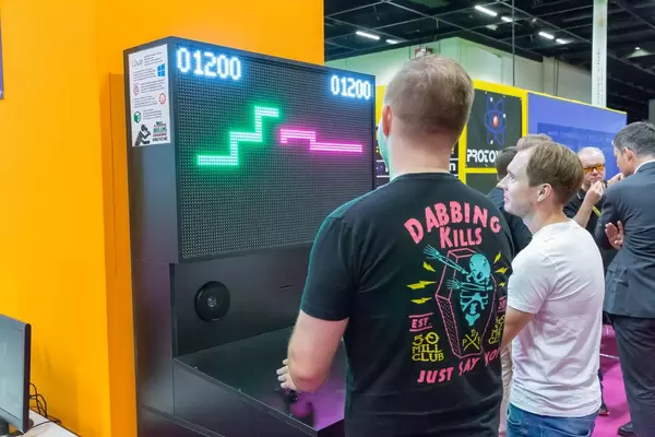 Zwei Besucher spielen auf einem Arcade-Automaten