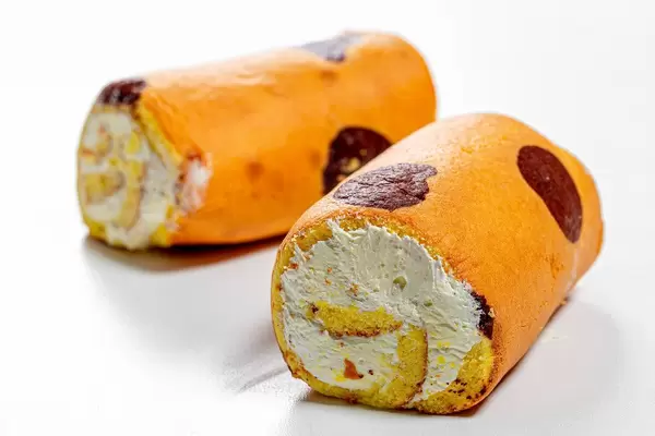 Zwei Biscuit Rollen mit Sahne auf weißem Hintergrund