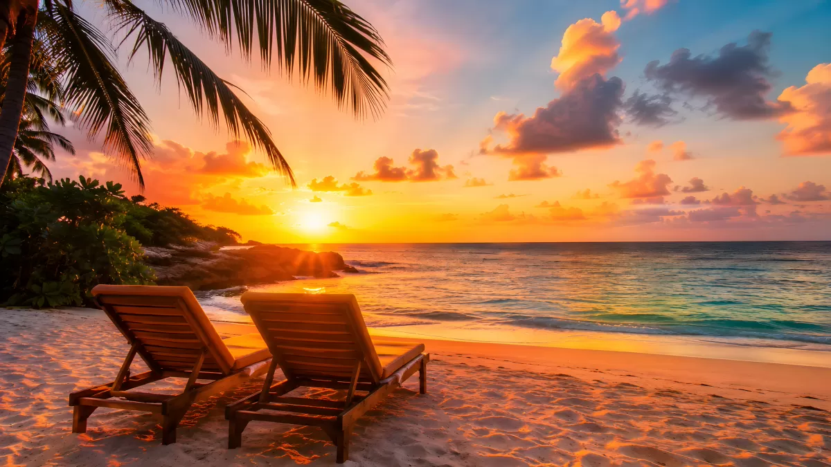 Zwei Liegestühle am Strand bei leuchtendem Sonnenuntergang