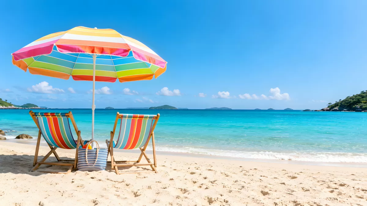 Zwei Liegestühle mit Sonnenschirm am türkisen Meer