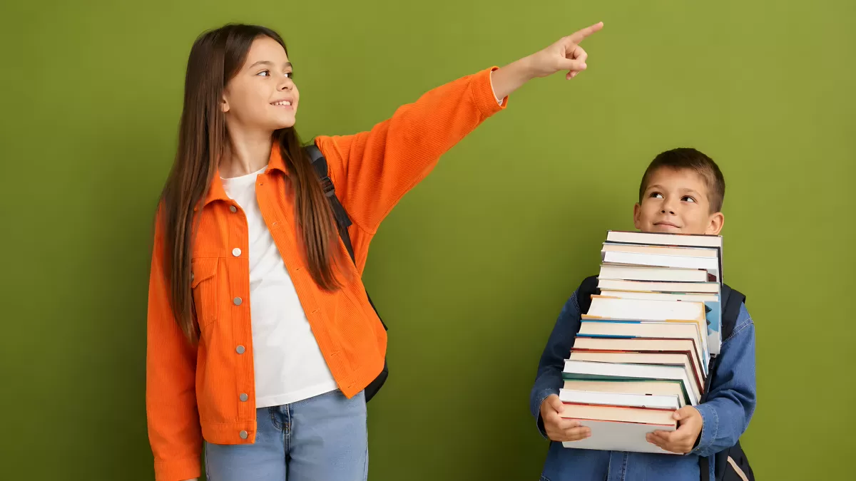 Zwei Schulkinder mit Bücherstapel zeigen in die Ferne
