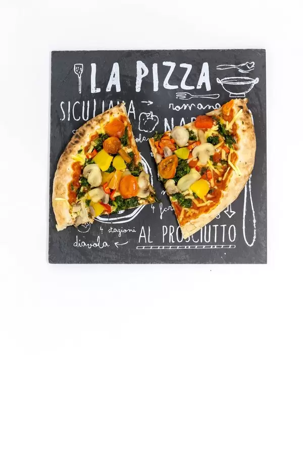 Zwei Stücke Gemüsepizza auf einem Pizzeriaschild - mit Tomaten, Pilzen, Spinat und gelber Paprika