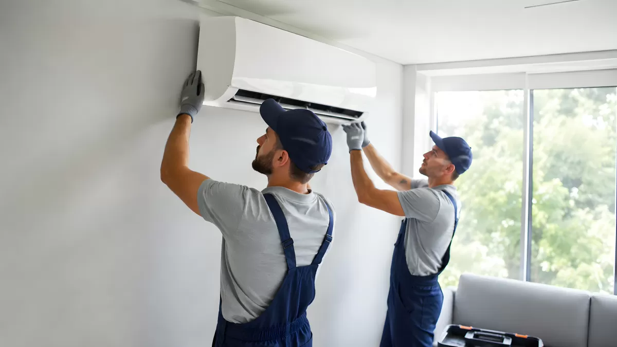 Zwei Techniker installieren Klimaanlage an Wand