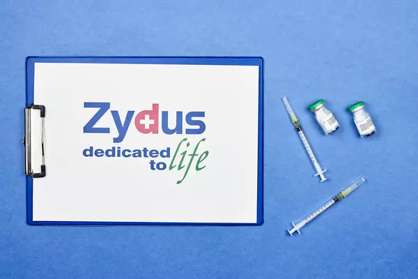Zydus Cadila vaccines with syringes on blue background
