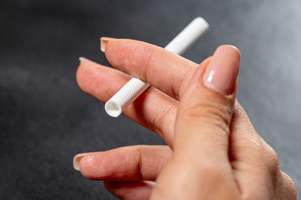A cigarette in a woman's hand. The concept of addiction and bad habits (Flip 2019)