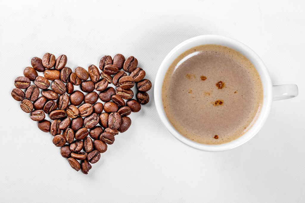 A Cup of coffee and a heart made of coffee beans