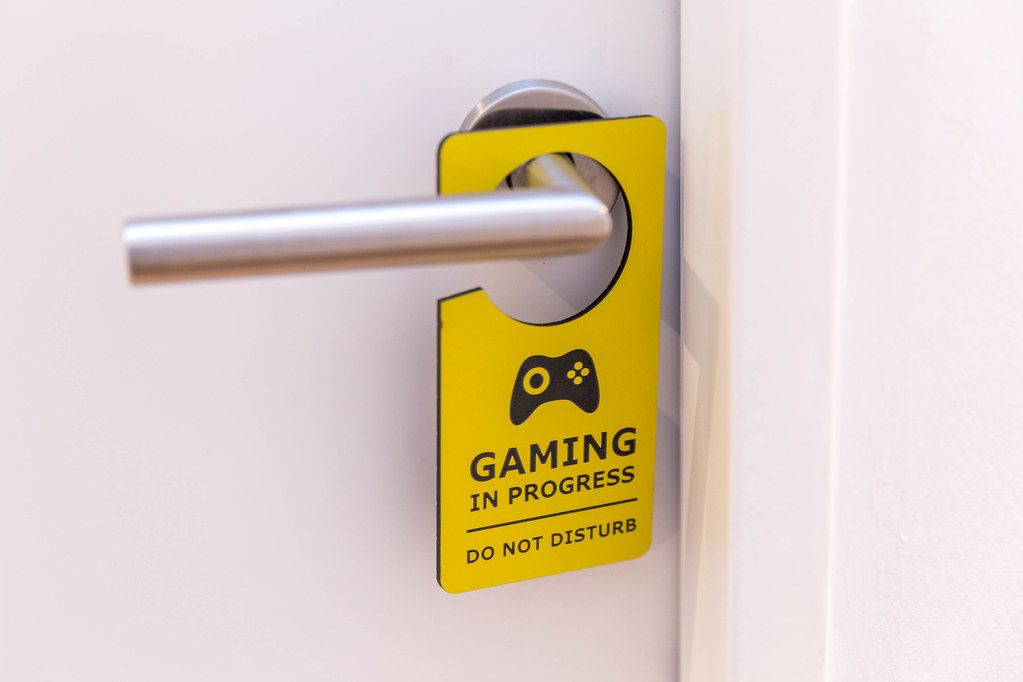 A gamer's room: white door with yellow 
