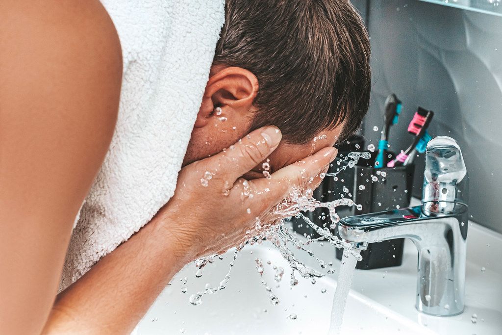 A man washes his face with clean water. The concept of personal hygiene (Flip 2019)