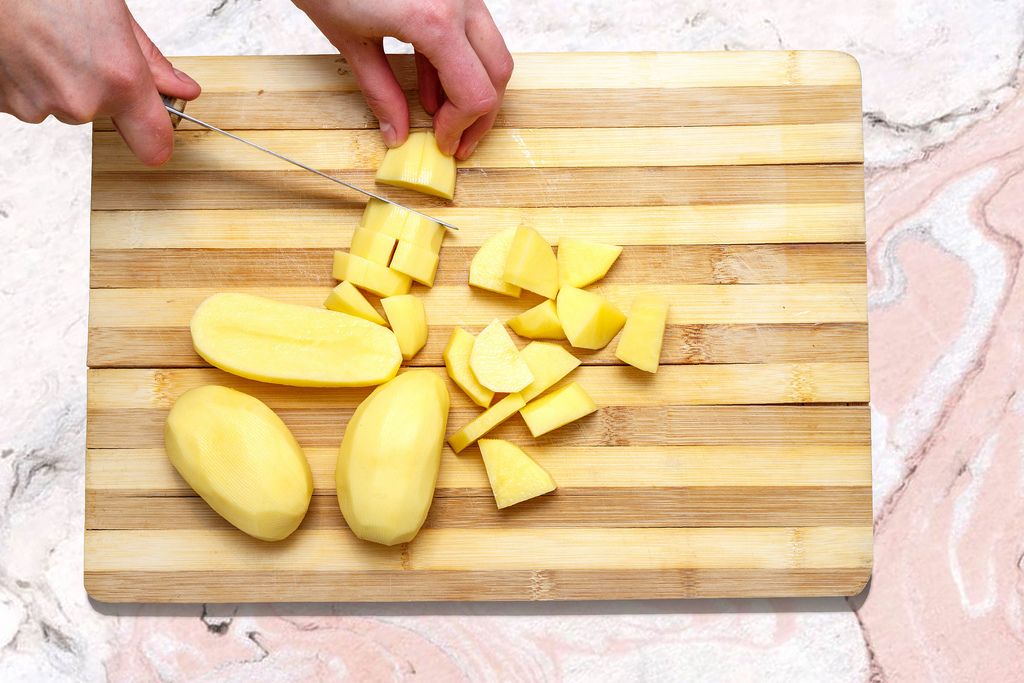A slices of potatoes on wooden board on marble table