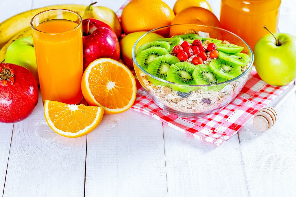A variety of cereals with honey, fresh fruit and juice for a healthy diet
