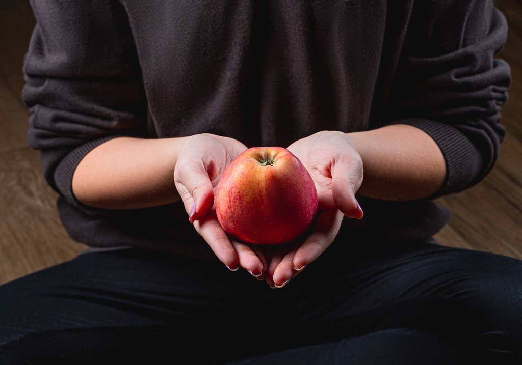A woman holds a red apple in her hands. Healthy eating concept (Flip 2020)