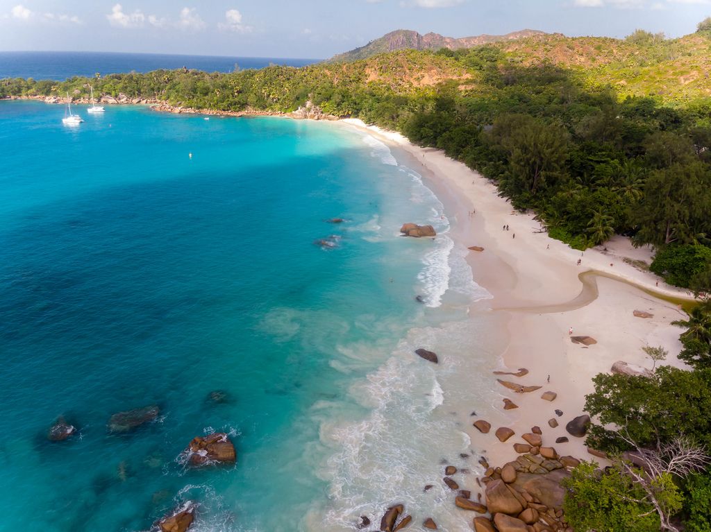 Aerial photography of Praslin with waves of the turquoise blue sea at the beach of Anse Lazio, Seychelles