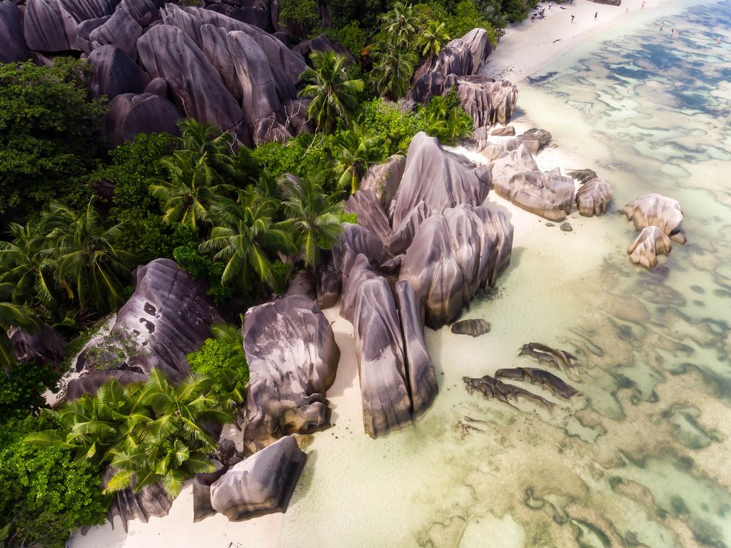 Aerial photography shows granite rocks at the shore of Anse Source d'Argent Beach in La Digue, Seychelles