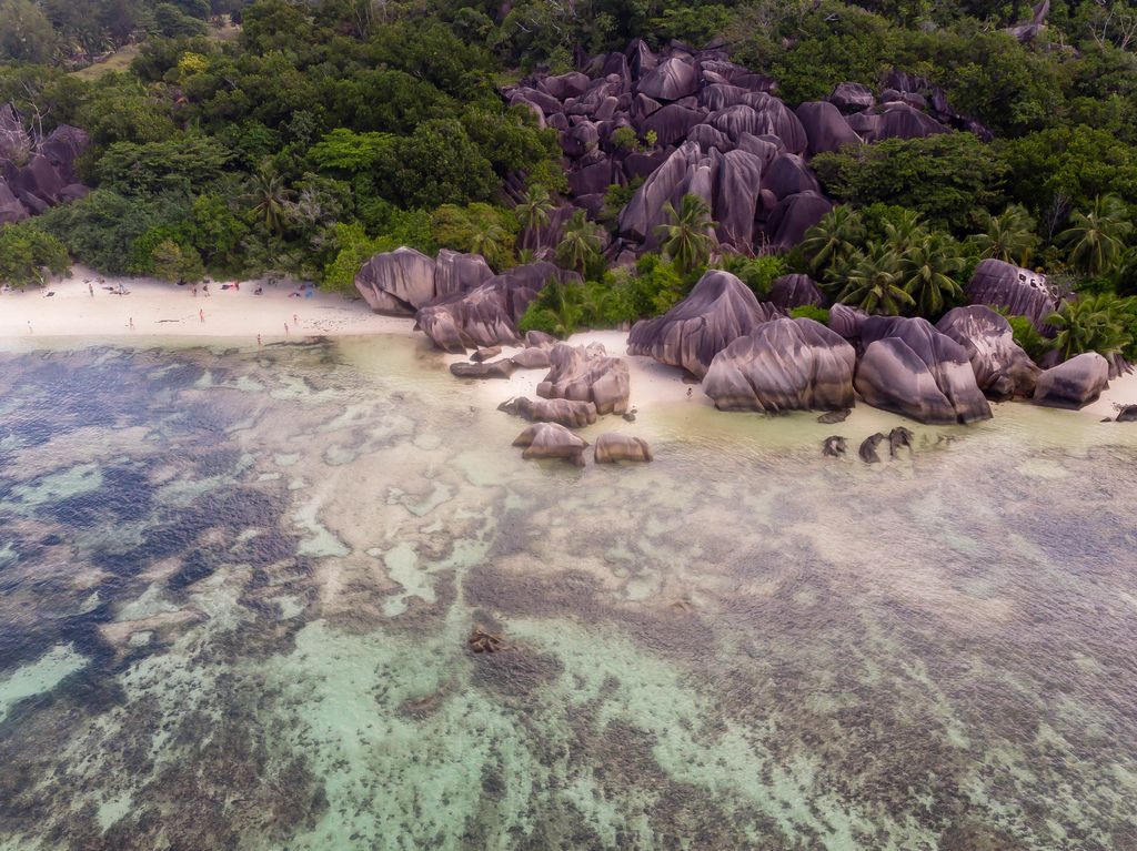 Aerial Picture of a sea of granite rocks on white sand and tropical forest at Anse Union in La Digue, Seychelles