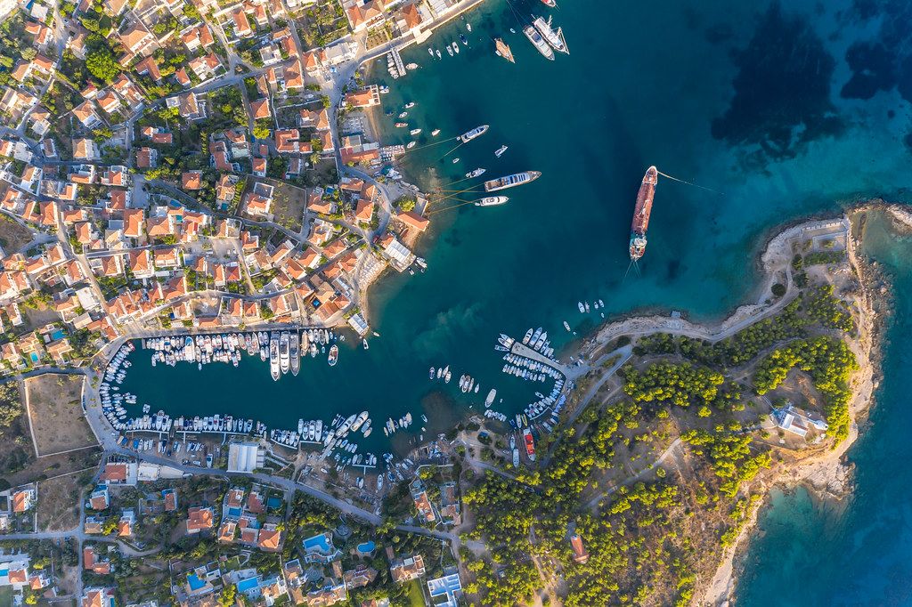 Aerial view of the Mediterranean island Spetses, Greece, with coastal path and anchorage in the Argolic Gulf