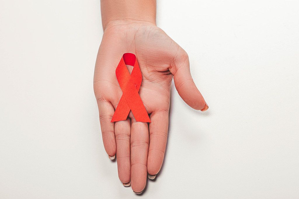 Aids red ribbon on woman's hand support for World aids day and national HIV/AIDS and aging awareness month concept (Flip 2019)