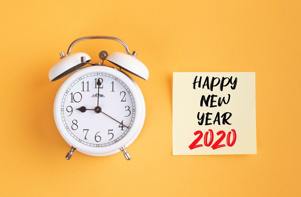 Alarm clock with handwritten text Happy New Year 2020