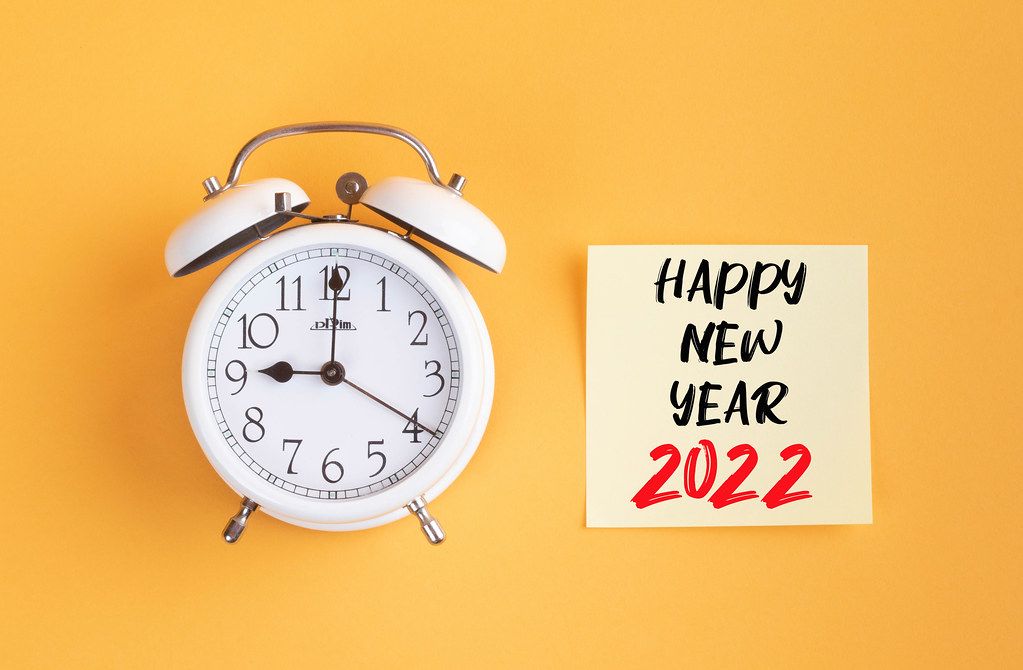 Alarm clock with handwritten text Happy New Year 2022