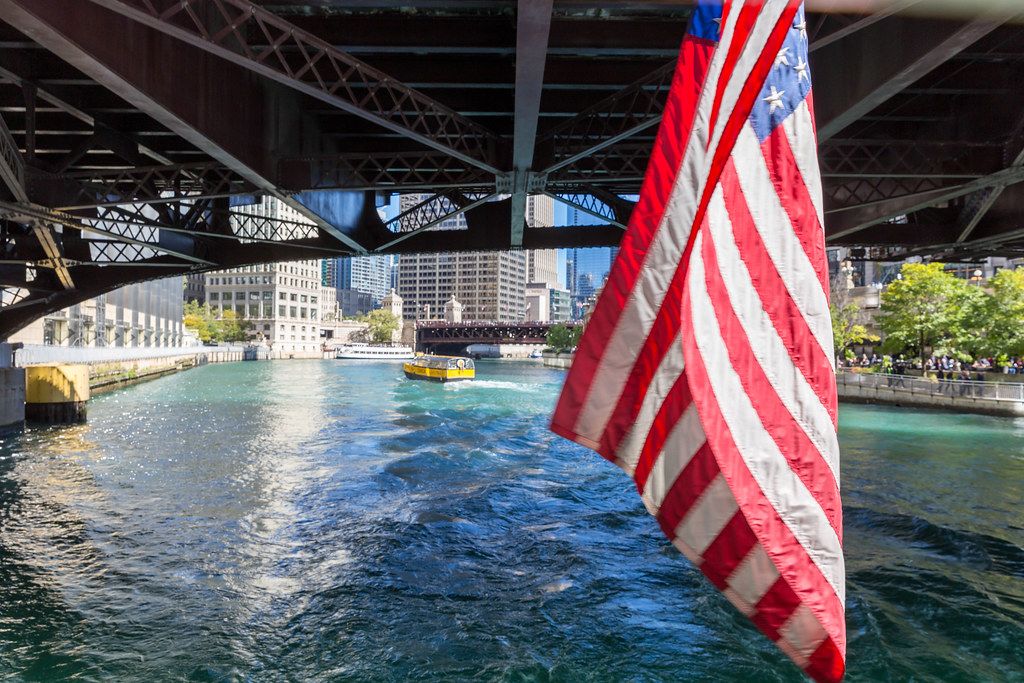 American flag hangs from a bridge over the Chicago river