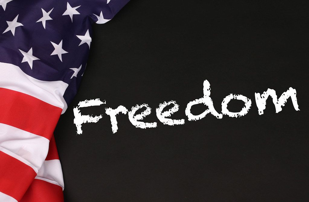 American flag with the text Freedom against a blackboard background