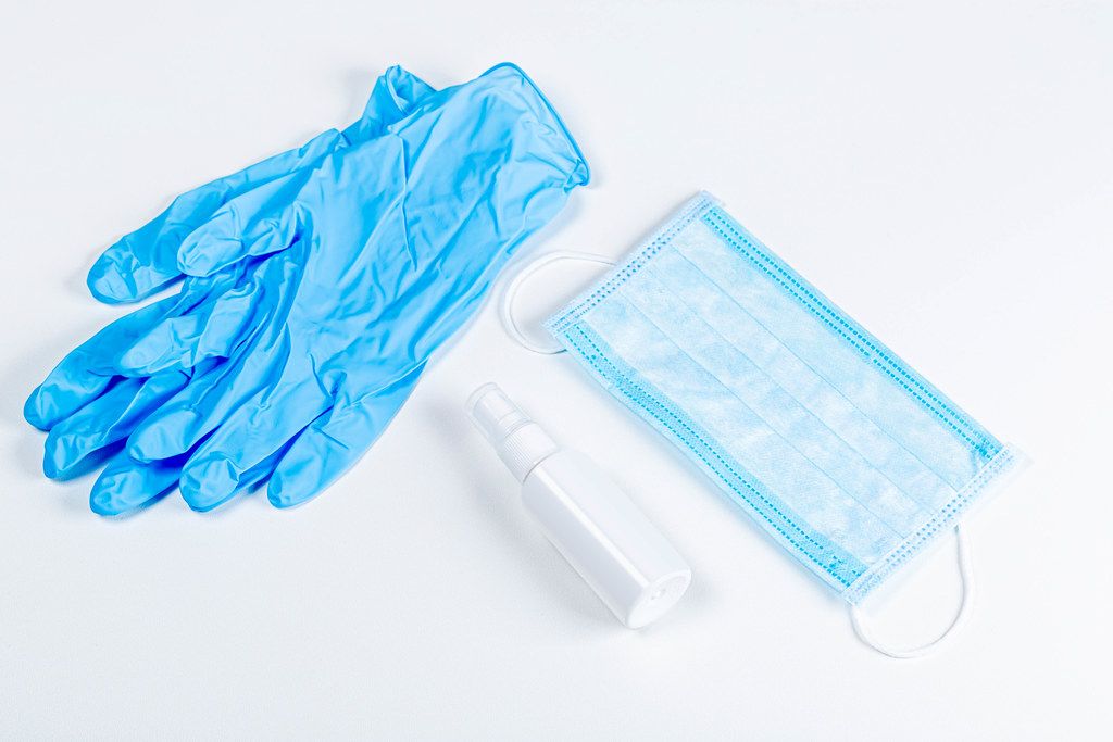 Antiseptic, gloves and medical mask on a white background - personal protective equipment