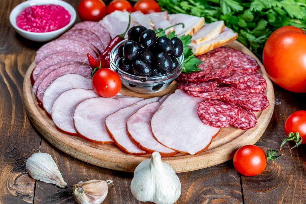 Assortment of sliced smoked sausages, salami and ham with vegetables (Flip 2019)