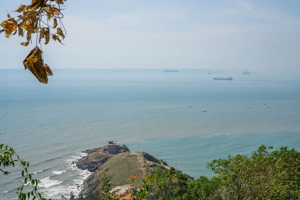 Aussicht von einem Berg in Vung Tau auf das Meer, eine kleine, angrenzende Insel und vorbeiziehende Boote