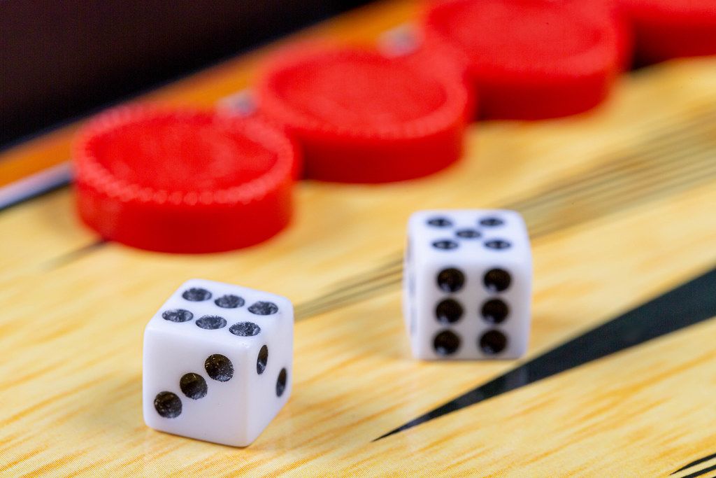 Backgammon game. Game dice lie on the backgammon board against the background of checkers (Flip 2019)