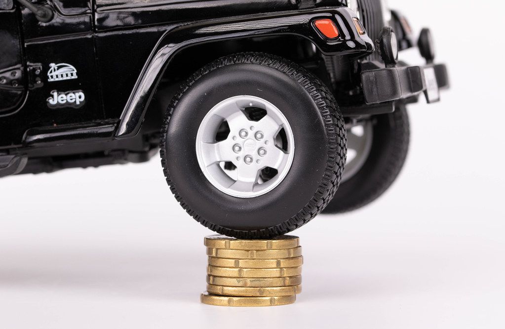 Big car wheel on top of stack of coins