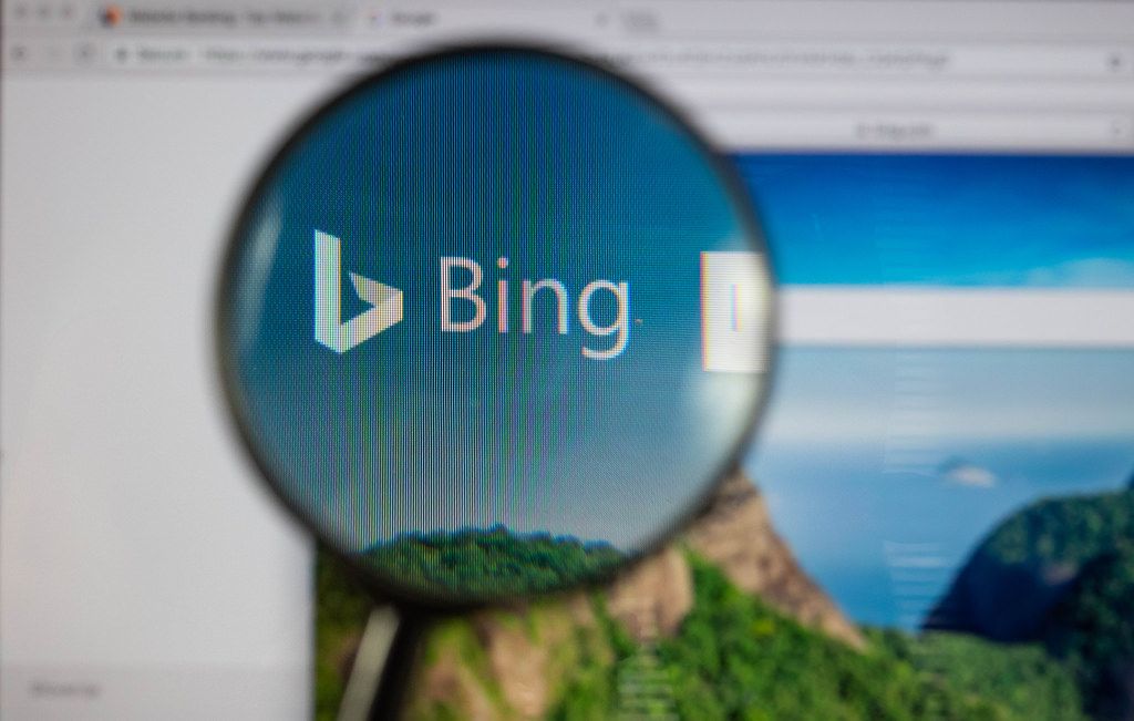 Bing-Logo am PC-Monitor, durch eine Lupe fotografiert