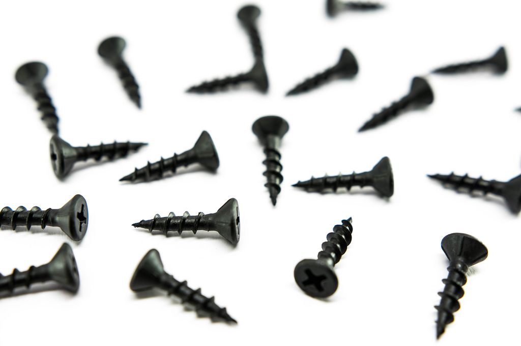 Black screws spread out on a white surface (Flip 2019) (Flip 2019) Flip 2019