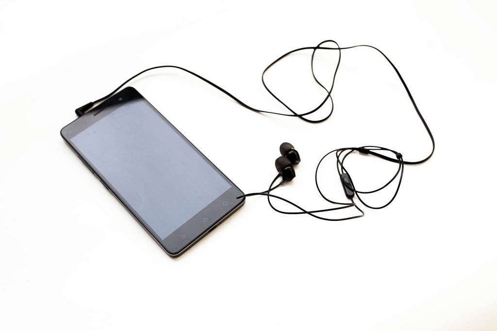 Black smartphone with earphones on white background (Flip 2019) (Flip 2019) Flip 2019