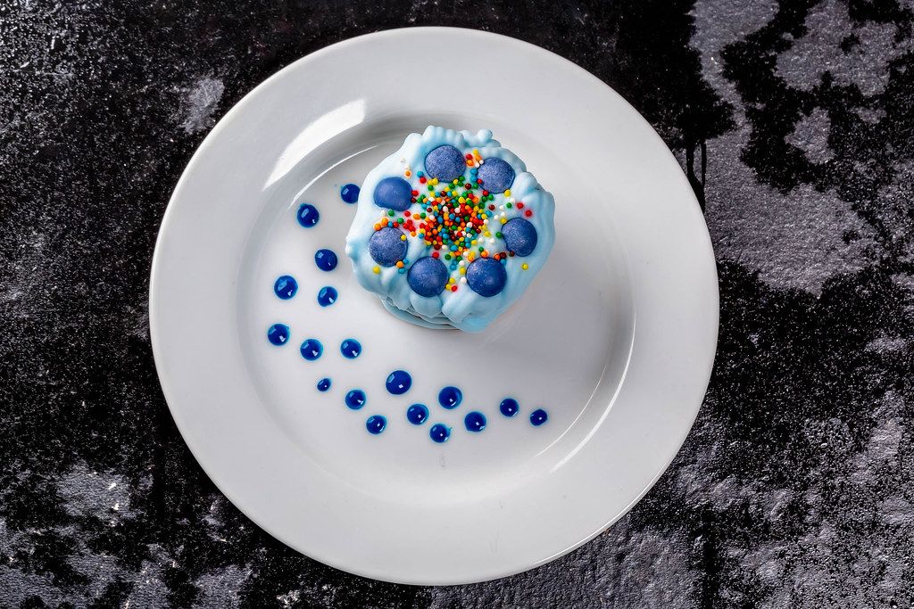 Blue dessert with multi-colored powder and blue cream
