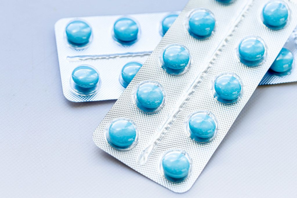Blue pills in packs on white background (Flip 2019) (Flip 2019)