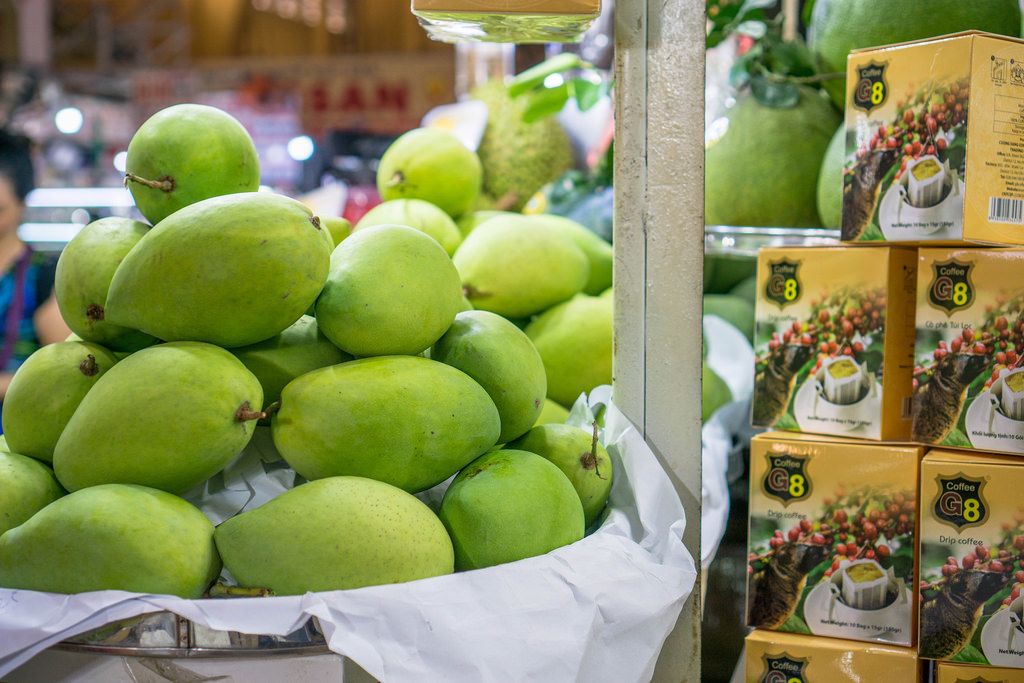 Bokeh mit Mangofrüchten im Fokus auf dem Ben Thanh Markt in Saigon