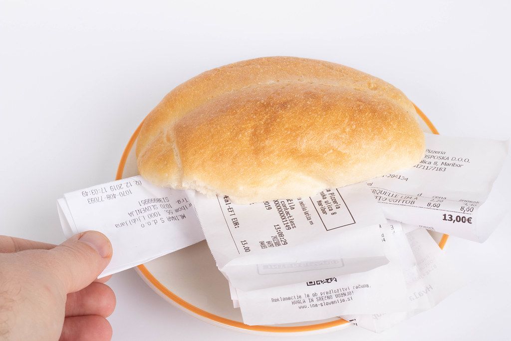 Bread roll full of receipts with human hand