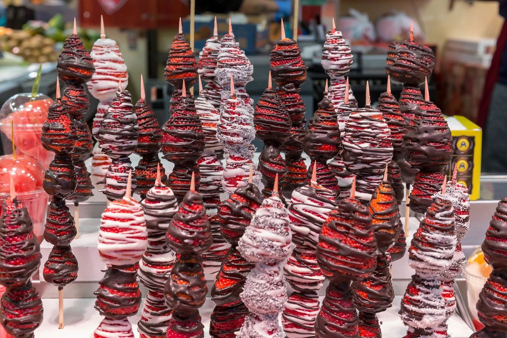 Brochetas - Erdbeerspieße mit Schokoladenüberzug als kreatives Fingerfood in der Markthalle Mercat de la Boqueria an den Ramblas in Barcelona, Spanien