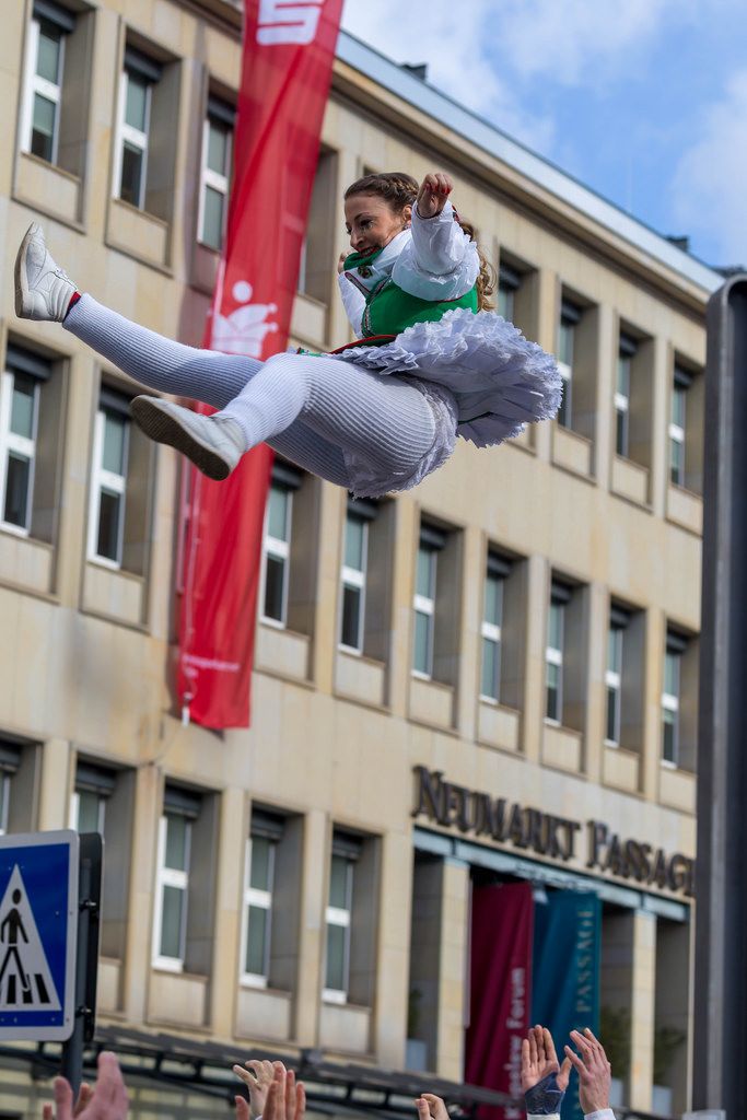 Bunt gekleidete Frau wird in die Luft geworfen - Kölner Karneval 2018
